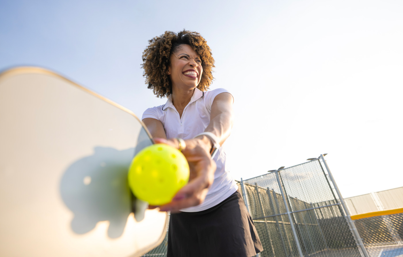 woman serving a pickleball
